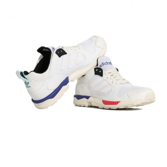 کفش ادیداس سفید مدل zx5000 سفید مخصوص پیاده روی از جنس توری و چرم که پا چپ به پا راست تکیه داده