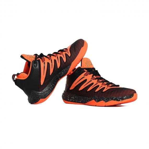 کفش معروف مایکل جردن نایک به رنگ مشکی و نارنجی 100% اصل که لنگه پای چپ به پای راست تکیه داده است