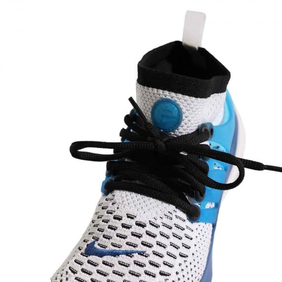 کفش بندی ورزشی آبی و سفید با لوگوی آبی Nike دوخته شده بر رویه کفش و ساق جورابی دور مچ پا از نمای نزدیک