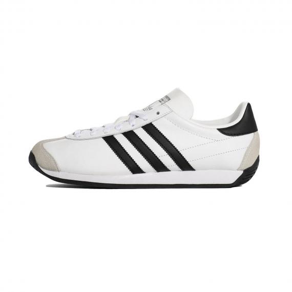 کفش پیاده روی ادیداس مدل کانتری با رویه سفید و 3 خط مشکی در کناره کفش و دو قسمت جیر کرم رنگ در جلو پنچه و پشت پاشنه و درج نام Adidas بر زبانه
