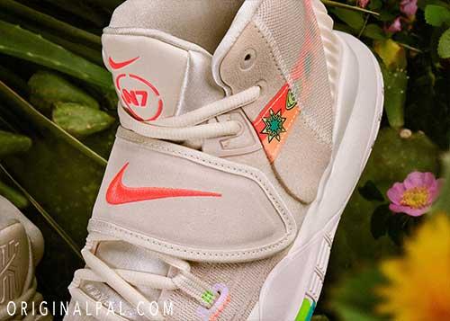 نمای نزدیک رویه کفش بندی بسکتبالی کایری 6 کرم با درج لوگوی Nike نارنجی و نام N7 بر روی زبانه