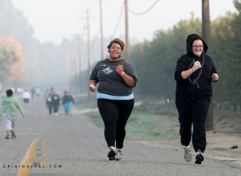 یک زن سیاه پوست و یک زن سفید پوست در حال دویدن در خیابان برای کم کردن وزن