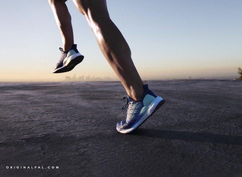 عکس دو پای یک مرد در حال دویدن روی زمین سیمانی با کفش اسپرت